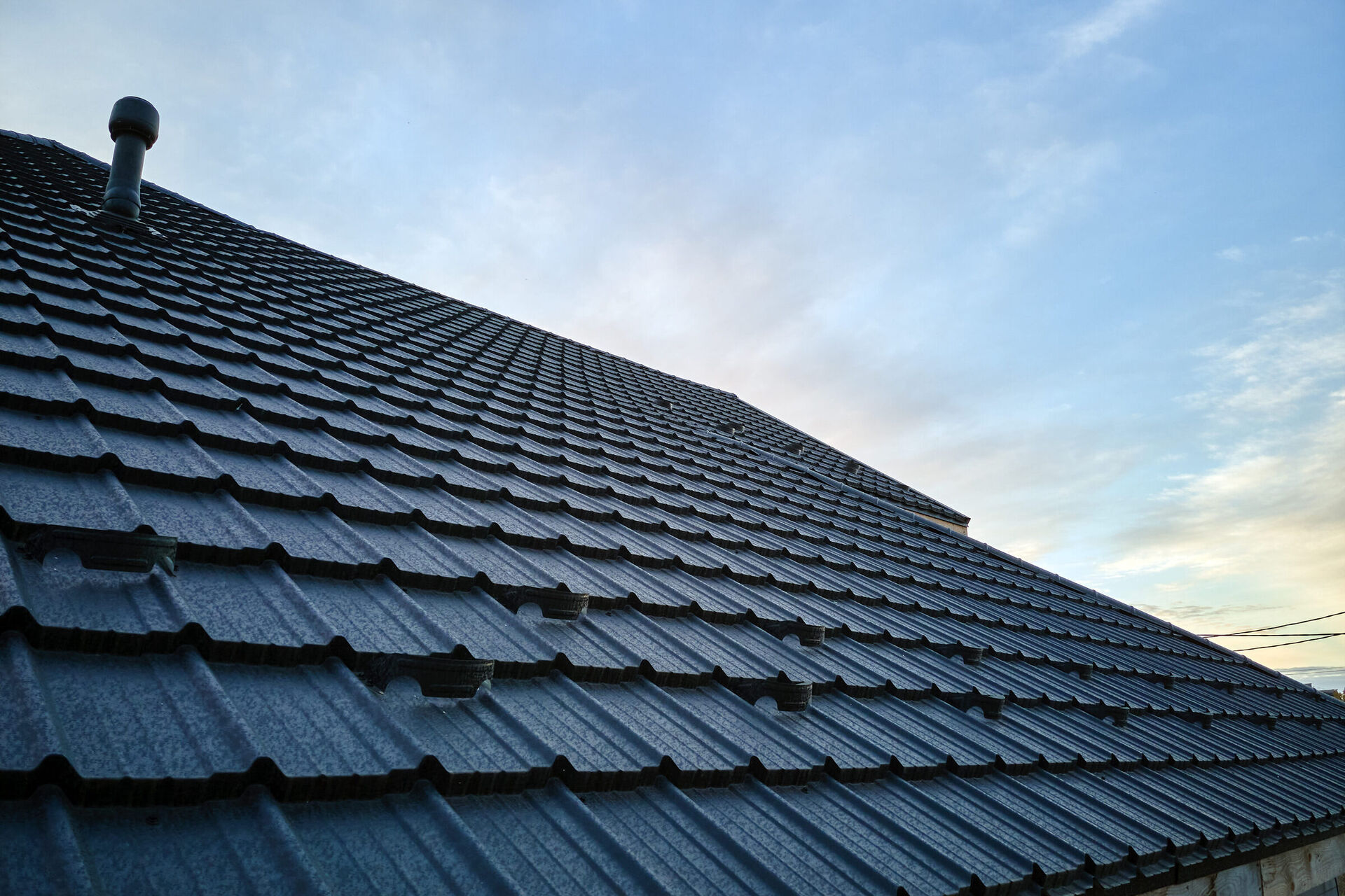 Technician safely soft washing a residential roof